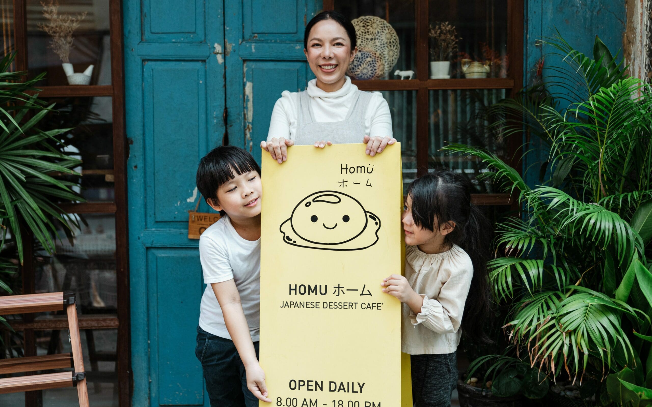 A woman and two children holding up a yellow sign promoting small business automation.